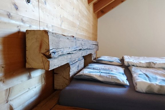 Balkenbett aus alten Strickwänden